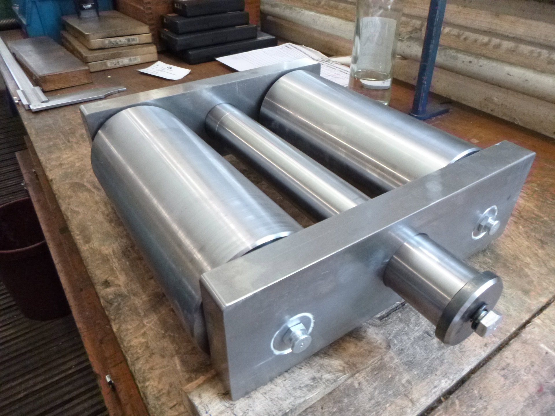 Eine Metallwalze auf einem Holztisch, silbern, glänzend und robust.
